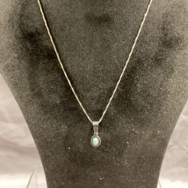 Delicate silver opal pendant necklace with a vibrant gemstone.