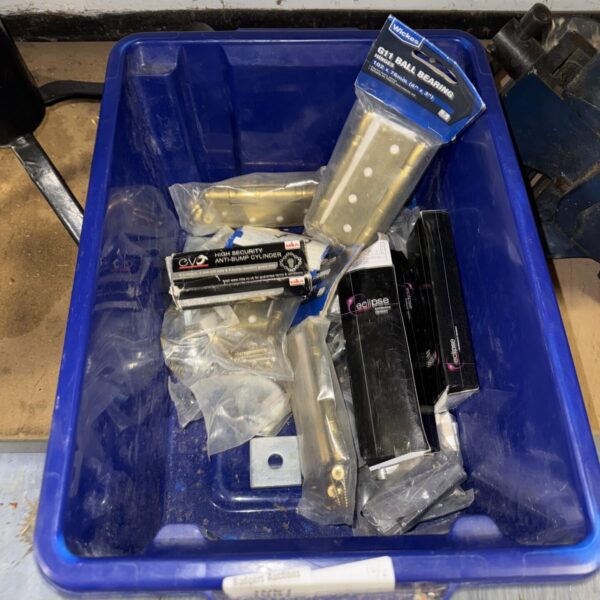 Assorted metal hardware in a plastic storage box.