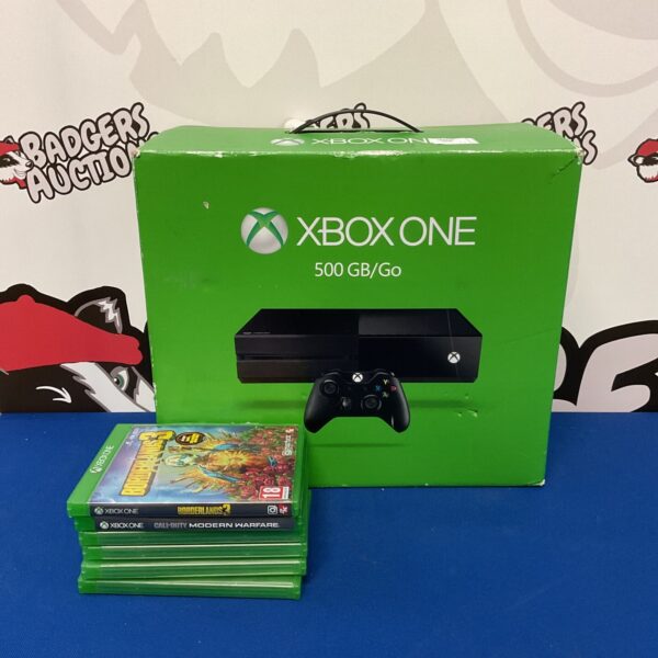 Xbox One console with games and cables for sale.