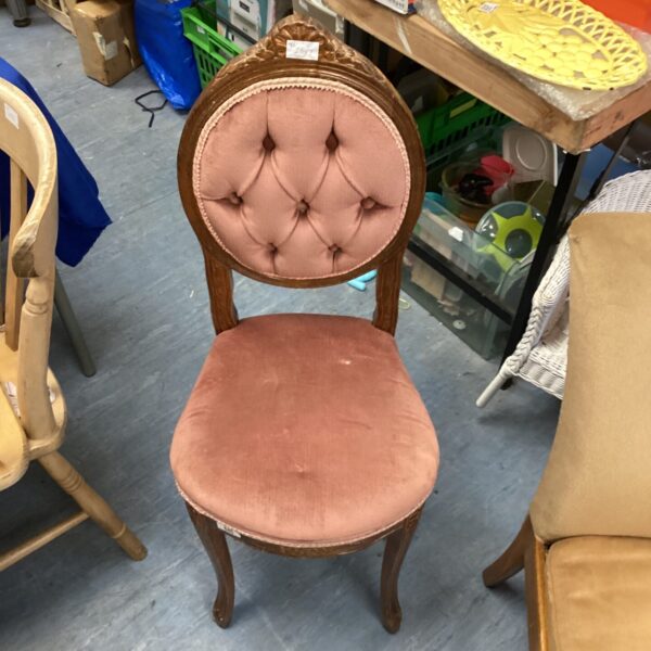 Richly coloured Victorian button back chair with carved wooden frame.