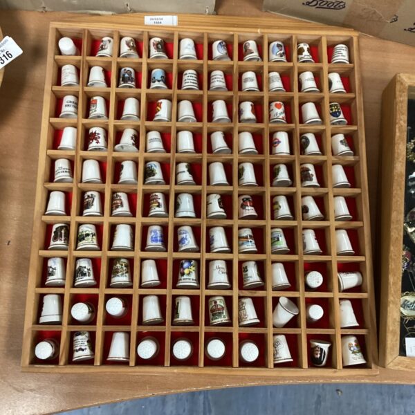 Vintage thimble collection displayed in a wall-hanging frame.