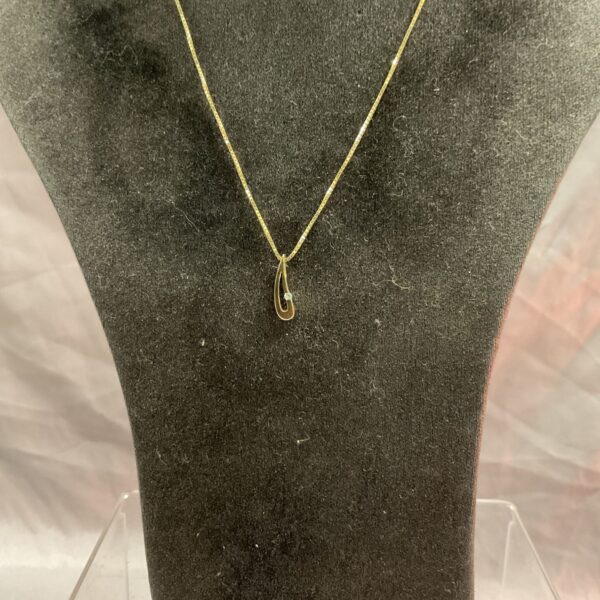 Sparkling 9ct gold diamond pendant necklace on a display.