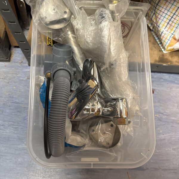 A box of assorted used plumbing fixtures and fittings.