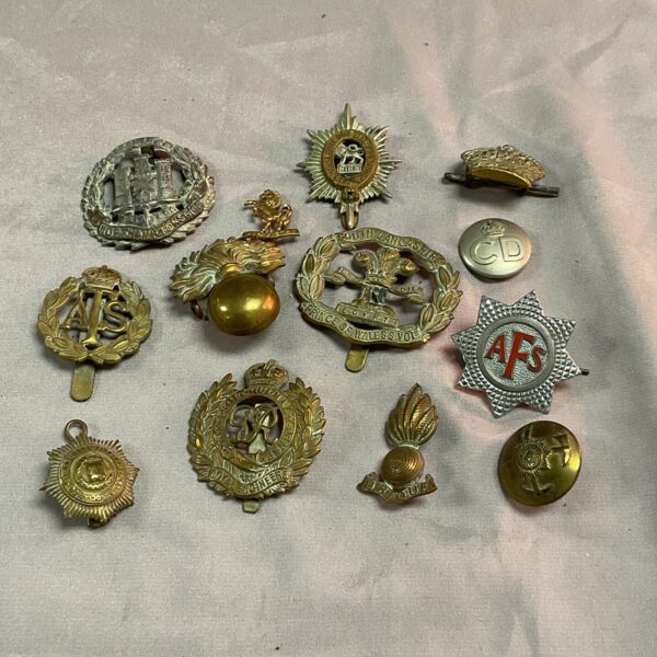 Vintage British Army cap badges from WW2 era military collection.