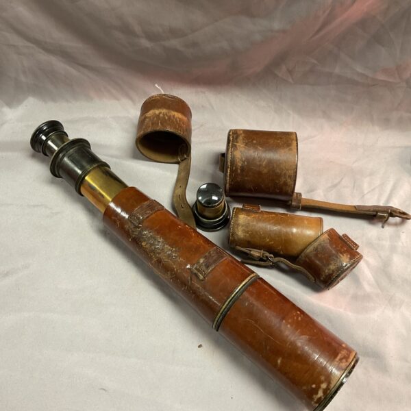 Antique military telescope in aged leather case, collectible instrument.