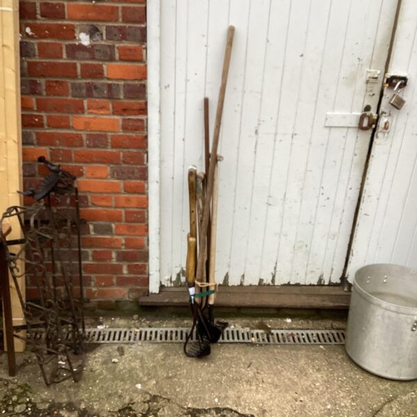 Vintage garden tools set including rake, shovel, and hoe.