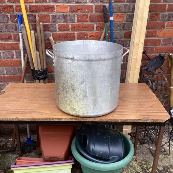Large aluminium cooking pot, showing signs of use and wear.
