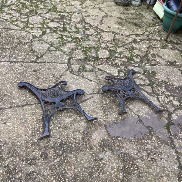 Ornate wrought iron bench ends for garden seating.