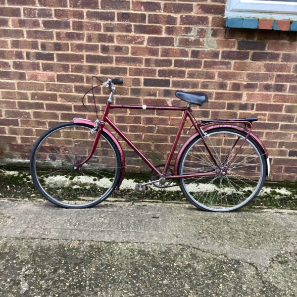 Red vintage bicycle with mudguards, classic retro style.