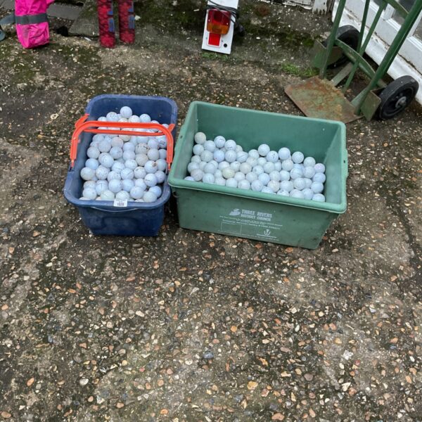 Two tubs filled with a large quantity of mixed golf balls.
