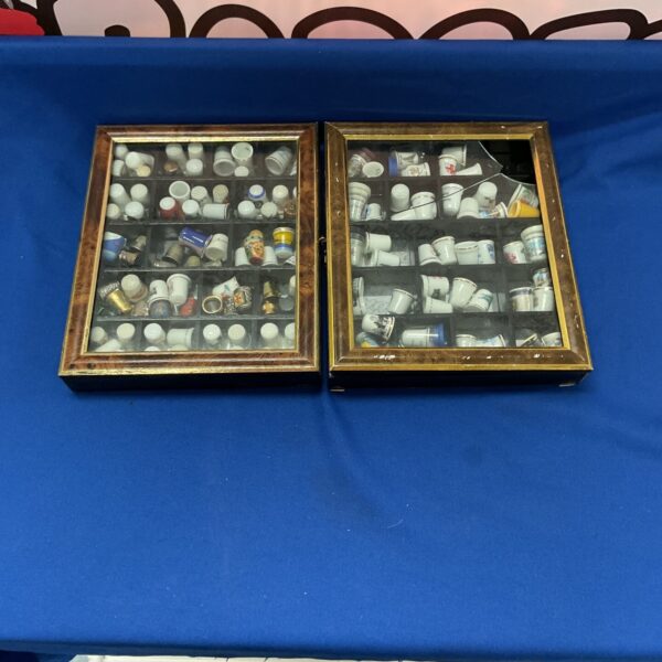 Vintage wooden display case showcasing a ceramic thimble collection.