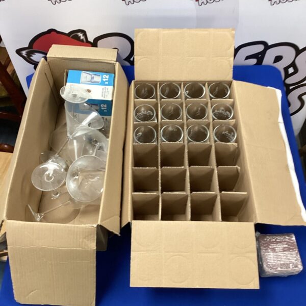 Twelve Carlsberg half-pint glasses with a box of cocktail glasses.