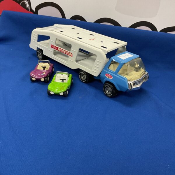 Vintage Tonka car transporter with two Tonka cars on display.