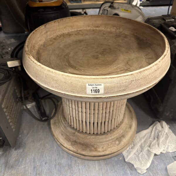 Front view of a wooden Grecian style plant stand.