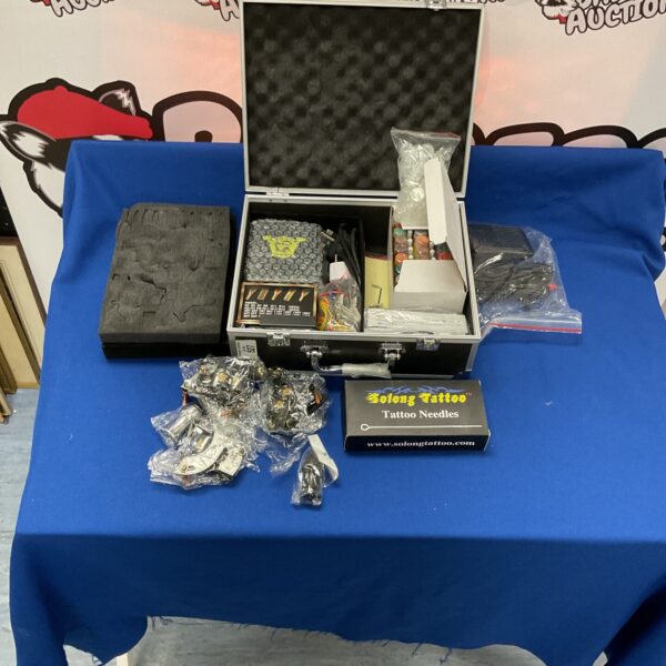 Solong tattoo kit open, showing gun, needles and ink.
