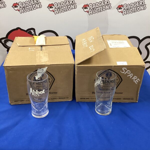 Lot of twenty-four Abbot Ale pint glasses in a cardboard box.