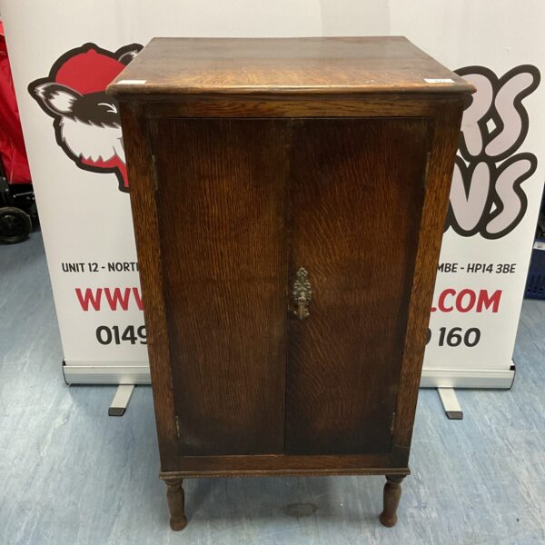 Front view of antique oak shirt cupboard with floral inlay.