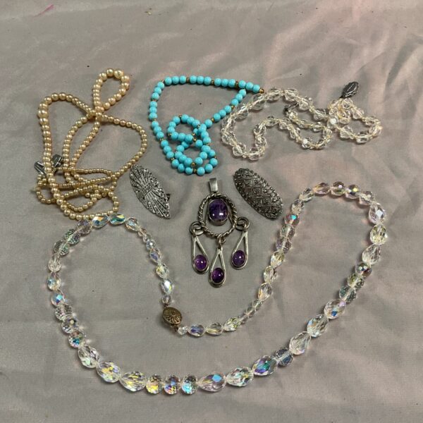 Vintage costume jewellery lot featuring necklaces and brooches.