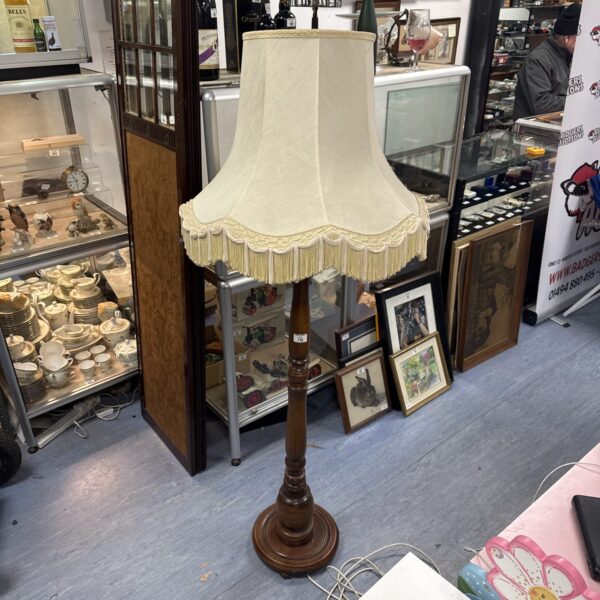 Vintage wooden standard floor lamp with cream shade.
