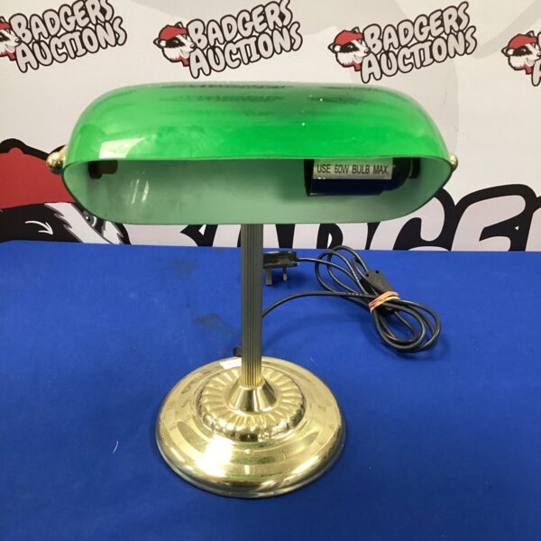 Vintage green glass banker's lamp on a dark surface.