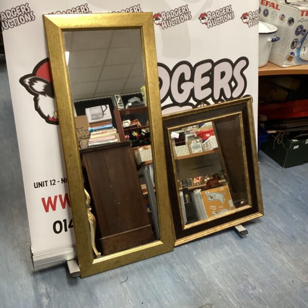 Vintage gold framed mirror with ornate detailing.