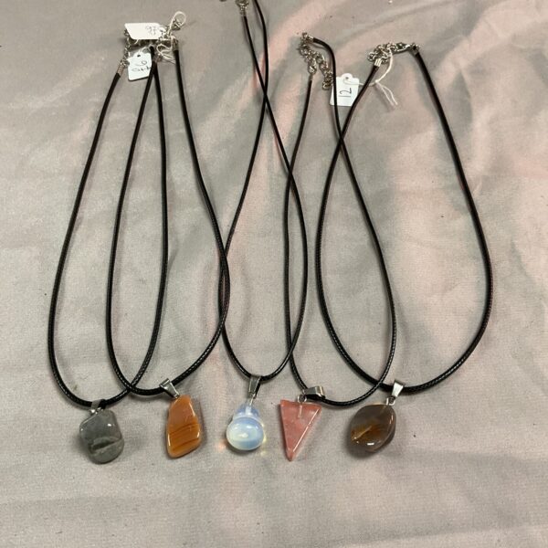 Grey stone pendant necklace on black cord.