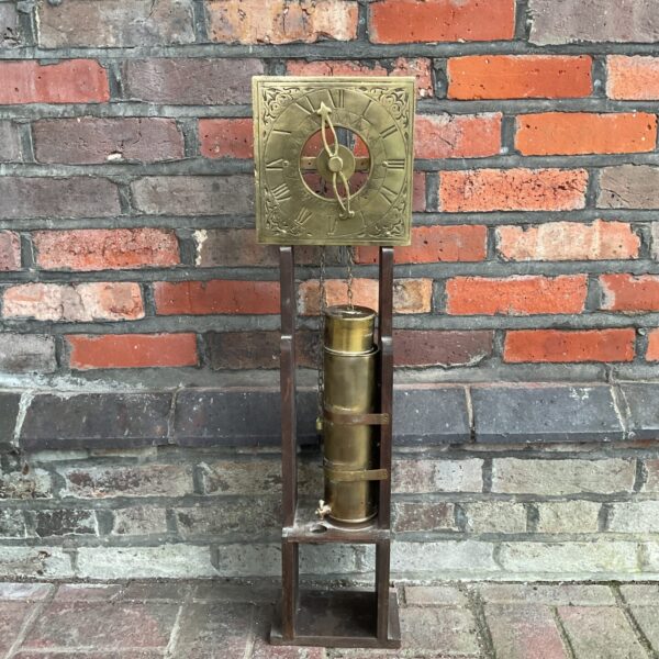 Antique brass water clock with Roman numeral face.
