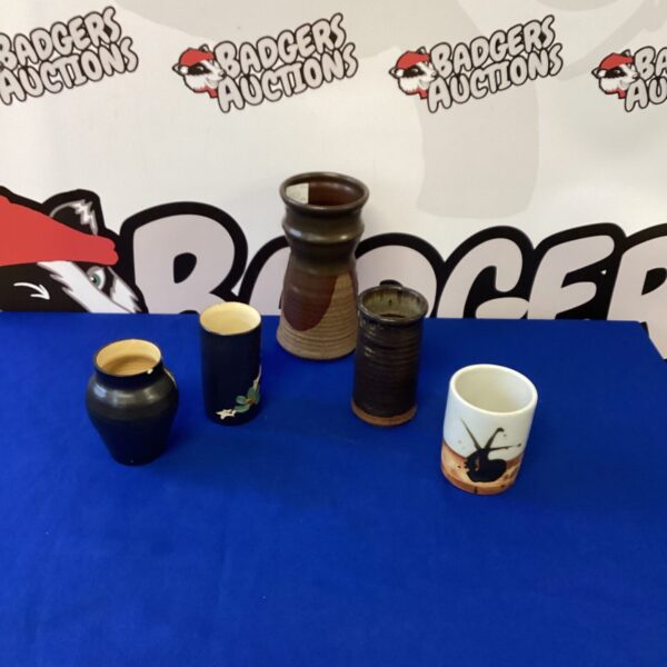 Group of five handmade glazed ceramic vases for display.