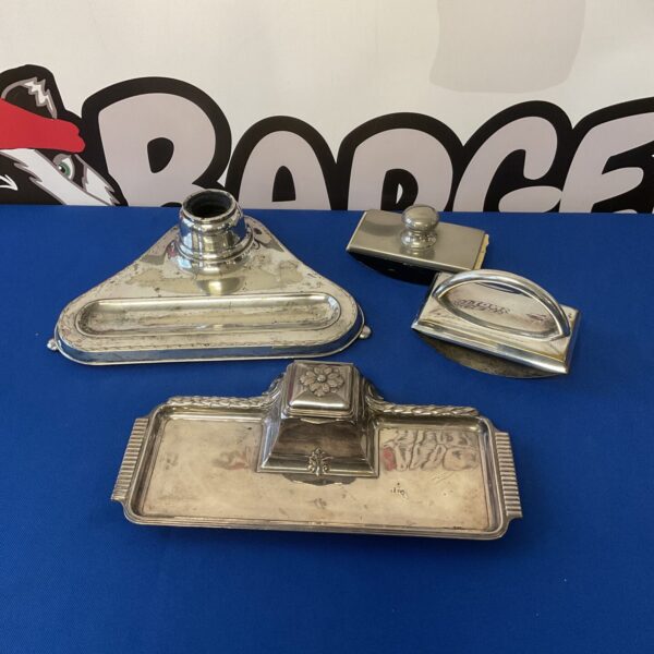 Vintage silver plate inkwell and blotter set on a desk.