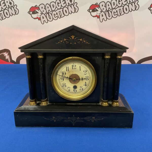 Front view of a Victorian slate mantle clock with Roman numerals.