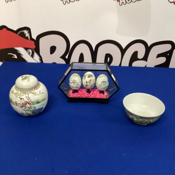 Framed display of Chinese porcelain bowls and painted eggs.