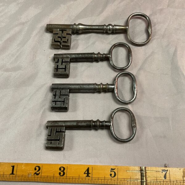 Lot of four antique Victorian safe keys with ornate bows.