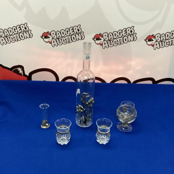 Clear decorative bottle and glasses set for home bar display.