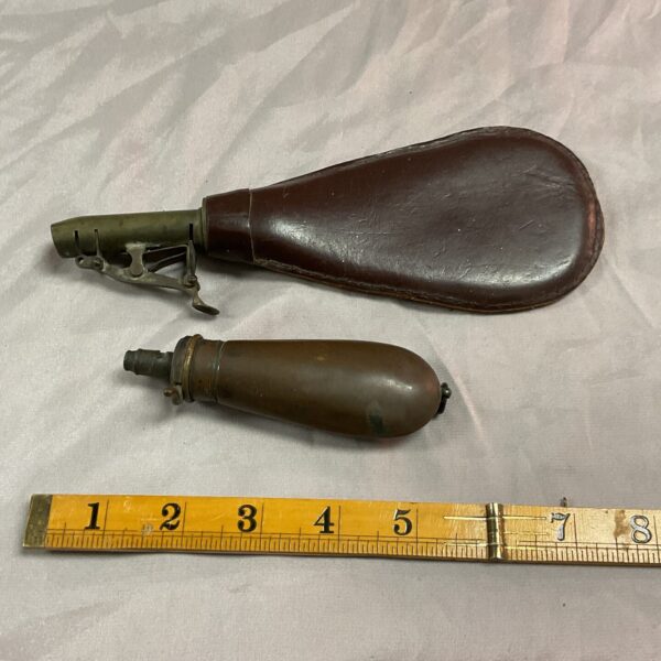 Antique leather and copper powder flask for muzzleloading firearms.