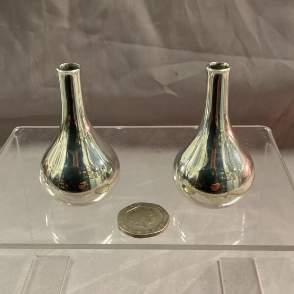 Vintage silver plated Dansk candle holders on a reflective surface.