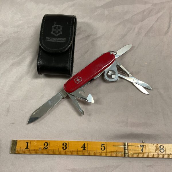 Classic red handled Victorinox Swiss Army Knife with leather pouch.