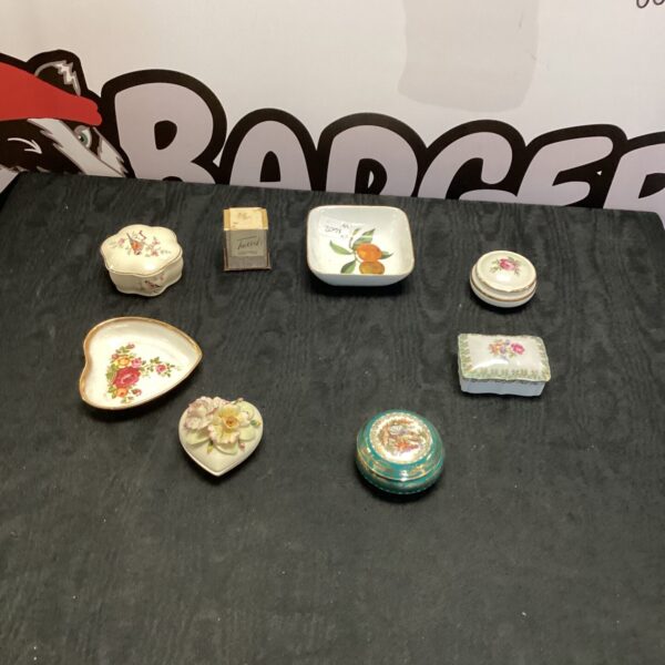 Vintage porcelain trinket boxes with floral designs, collectible items.