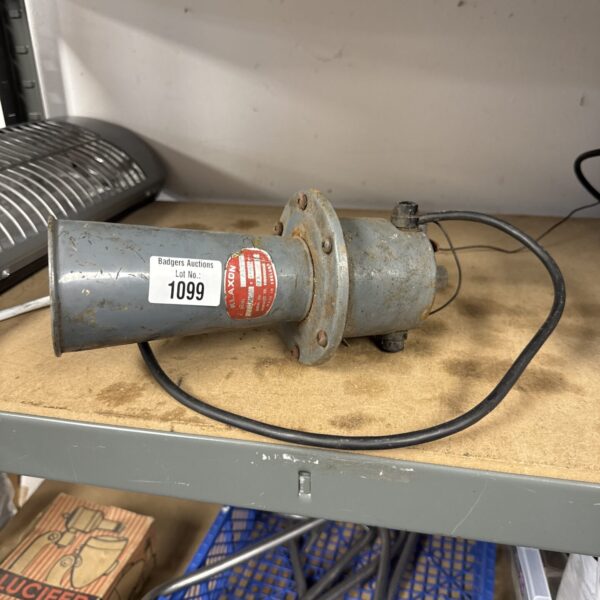 Side view of a vintage Klaxon siren, showing its metal construction.