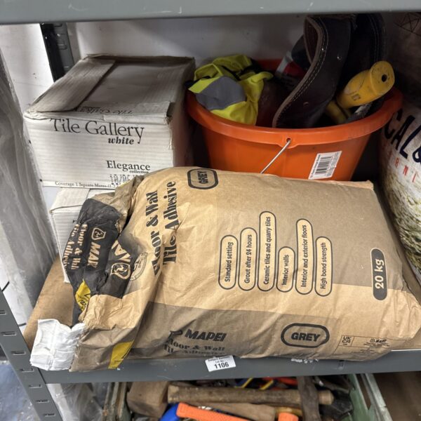 Overview of tile adhesive, tiles, and tools lot for DIY projects.