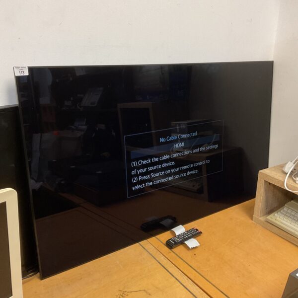 Front view of a Samsung 55” HD television with remote.