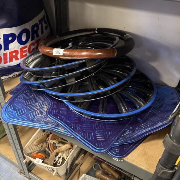Vintage car wheel trims, floor mats, and steering wheel cover.