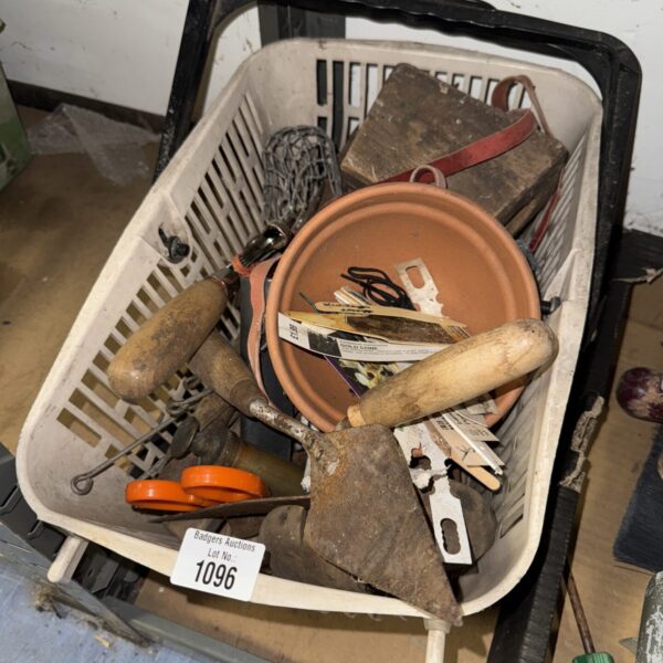 Assorted tools and hardware in a plastic basket, including a trowel.
