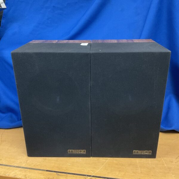 Pair of vintage Mission Model 70 bookshelf speakers in a home setting.