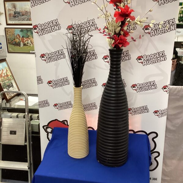 Tall pottery vases with artificial flowers, a striking home decor piece.