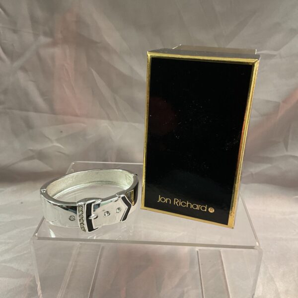 Silver-tone John Richard bracelet with a hinged buckle closure.