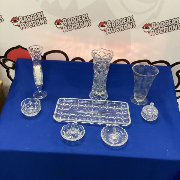 Vintage cut glass vase and decorative items on display.