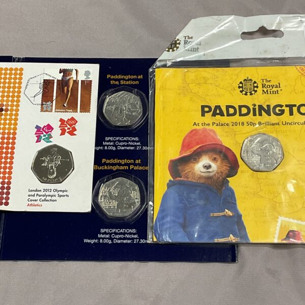 Sealed packaging of Paddington 50p coins and Olympic commemorative coins.