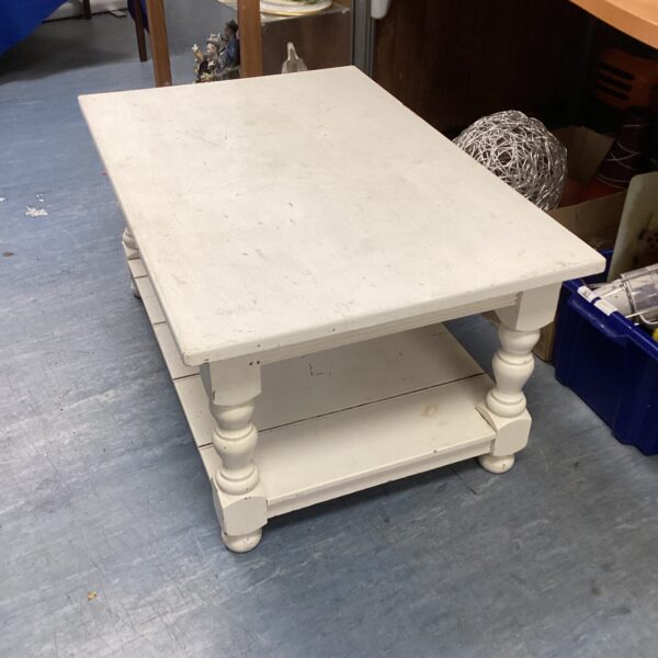 White rustic coffee table with lower shelf, farmhouse style living room.