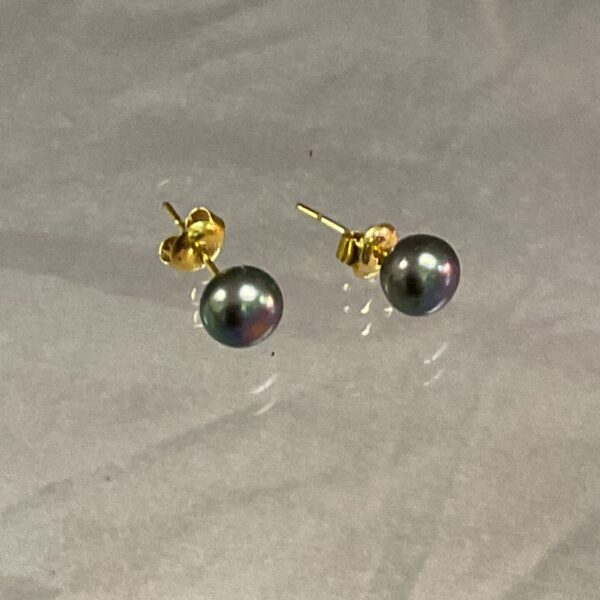Close-up of 14ct gold and pearl stud earrings.