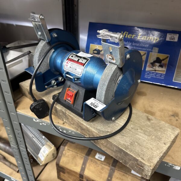 Blue Clarke bench grinder with grinding wheel and protective shield.